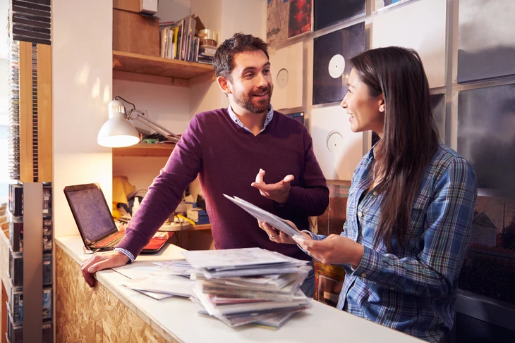 Homme et femme travaillant derrière le comptoir dans un magasin de disques